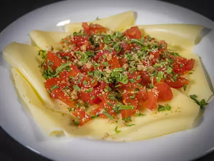 Carpaccio di formaggio con rucola, pomodori e noci